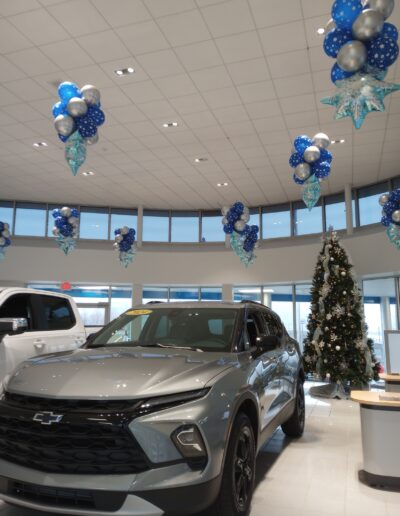 Floating balloon columns in blue and silver with snowflakes in dealership showroom